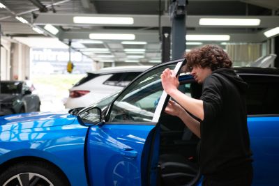 Personne remettant une voiture d'occasion esthétiquement à neuf.