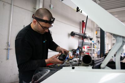 Personne du service après-vente s'occupant d'une voiture d'occasion et de ses vices cachés.